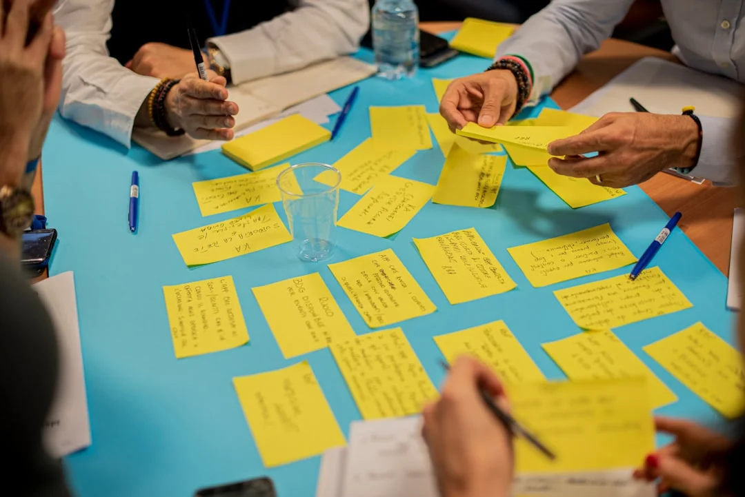 Vue rapprochée d’un planificateur de stratégie SEO avec des post-it colorés et un crayon sur un carnet.